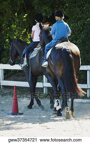 Rear view of a boy with his sister horseback riding View Large Photo Image Stock Image - Rear view of a boy with his sister horseback riding. Fotosearch