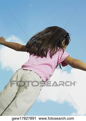 Rear view of a girl with her arms outstretched View Large Photo Image Stock Image - Rear view of a girl with her arms outstretched. Fotosearch
