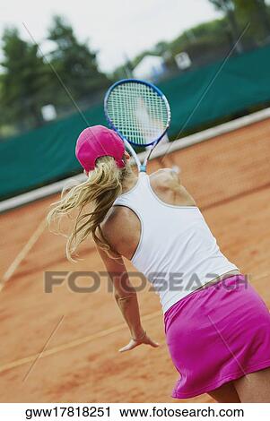 Rear view of a mid adult woman playing tennis with another person View Large Photo Image Stock Image - Rear view of a mid adult woman playing tennis with another person. Fotosearch