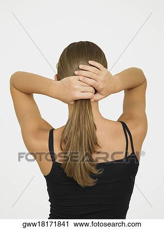 Rear view of a woman adjusting her hair View Large Photo Image Stock Image - Rear view of a woman adjusting her hair. Fotosearch
