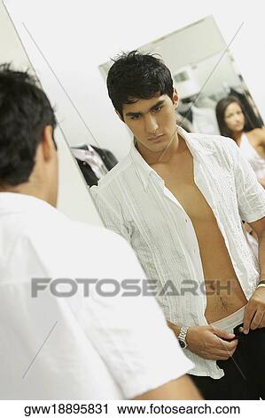 Rear view of a young man putting on pants in a clothing store View Large Photo Image Stock Image - Rear view of a young man putting on pants in a clothing store. Fotosearch