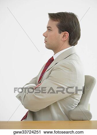 Side profile of a businessman sitting with his arms crossed View Large Photo Image Stock Image - Side profile of a businessman sitting with his arms crossed. Fotosearch
