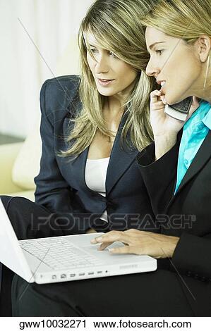 Side profile of a businesswoman using a laptop with a businesswoman beside her View Large Photo Image Stock Image - Side profile of a businesswoman using a laptop with a businesswoman beside her. Fotosearch