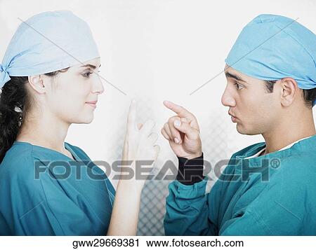Stock Image - Side profile of a male and a female doctor. Fotosearch