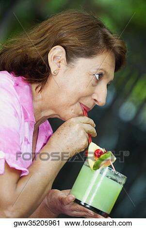 Side profile of a mature woman drinking juice View Large Photo Image Stock Image - Side profile of a mature woman drinking juice. Fotosearch