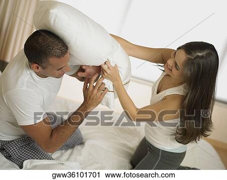 Side profile of a mid adult man with a young woman having a pillow fight on the bed View Large Photo Image Stock Image - Side profile of a mid adult man with a young woman having a pillow fight on the bed. Fotosearch