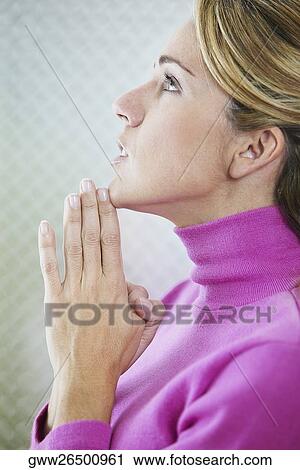 Side profile of a mid adult woman praying View Large Photo Image Stock Image - Side profile of a mid adult woman praying. Fotosearch