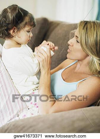 Side profile of a mid adult woman playing with her daughter View Large Photo Image Stock Image - Side profile of a mid adult woman playing with her daughter. Fotosearch