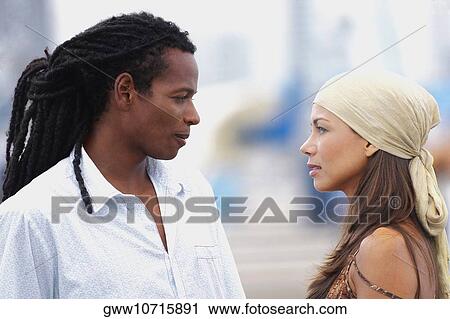 Side profile of a young couple looking at each other View Large Photo Image Stock Image - Side profile of a young couple looking at each other. Fotosearch