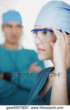 Side profile of a young female doctor holding his protective eyewear View Large Photo Image Stock Image - Side profile of a young female doctor holding his protective eyewear. Fotosearch