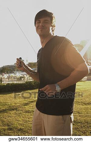 Side profile of a young man listening to an mp3 player View Large Photo Image Stock Image - Side profile of a young man listening to an mp3 player. Fotosearch