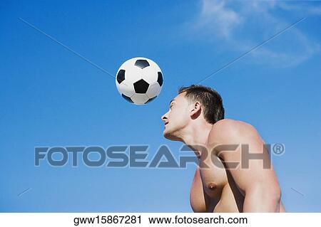 Side profile of a young man playing with a football View Large Photo Image Stock Image - Side profile of a young man playing with a football. Fotosearch