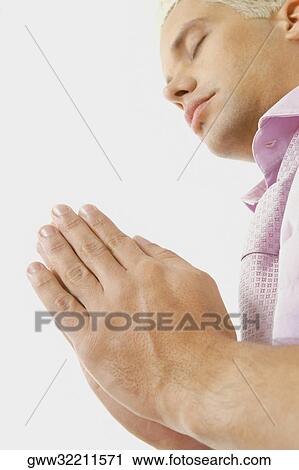 Side profile of a young man praying View Large Photo Image Stock Image - Side profile of a young man praying. Fotosearch