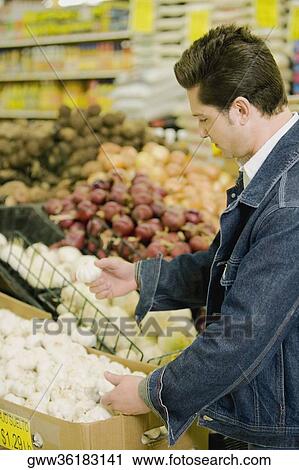 Side profile of a young man shopping in a supermarket View Large Photo Image Stock Image - Side profile of a young man shopping in a supermarket. Fotosearch