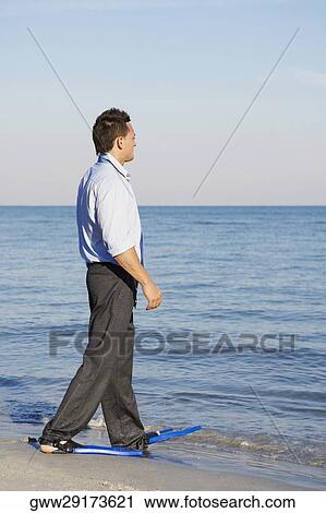 Side profile of a young man wearing flippers and walking on the beach View Large Photo Image Stock Image - Side profile of a young man wearing flippers and walking on the beach. Fotosearch