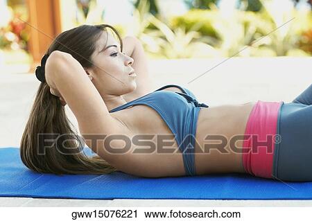 Side profile of a young woman doing sit-ups View Large Photo Image Stock Image - Side profile of a young woman doing sit-ups. Fotosearch
