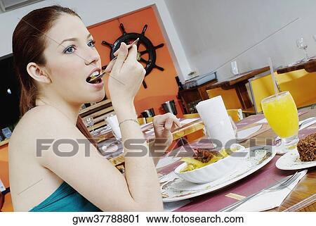 Side profile of a young woman eating View Large Photo Image Stock Image - Side profile of a young woman eating. Fotosearch