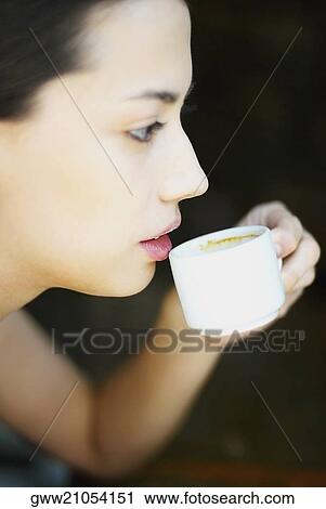 Side profile of a young woman holding a cup View Large Photo Image Stock Image - Side profile of a young woman holding a cup. Fotosearch