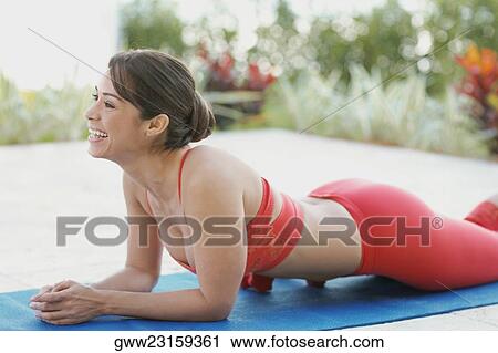 Side profile of a young woman lying on an exercise mat View Large Photo Image Stock Image - Side profile of a young woman lying on an exercise mat. Fotosearch