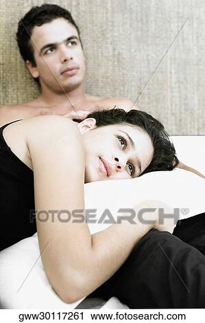 Side profile of a young woman lying with her head over a young man on the bed View Large Photo Image Stock Image - Side profile of a young woman lying with her head over a young man on the bed. Fotosearch