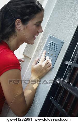 Side profile of a young woman ringing a doorbell View Large Photo Image Stock Image - Side profile of a young woman ringing a doorbell. Fotosearch