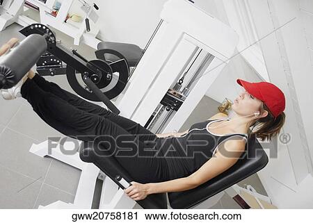 Side profile of a young woman exercising in a gym View Large Photo Image Stock Image - Side profile of a young woman exercising in a gym. Fotosearch