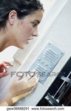 Side profile of a young woman using a doorbell View Large Photo Image Stock Image - Side profile of a young woman using a doorbell. Fotosearch