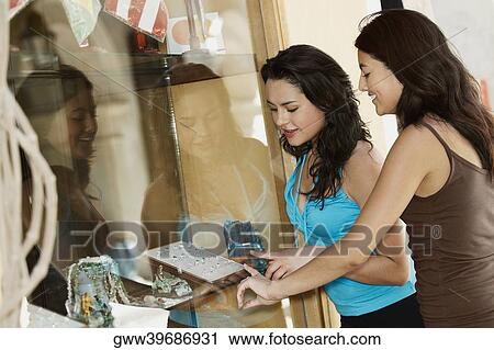 Side profile of two young women selecting rings in a jewelry store View Large Photo Image Stock Image - Side profile of two young women selecting rings in a jewelry store. Fotosearch