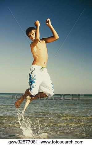 Teenage boy jumping in water View Large Photo Image Stock Image - Teenage boy jumping in water. Fotosearch