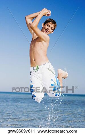 Teenage boy jumping on the beach View Large Photo Image Stock Image - Teenage boy jumping on the beach. Fotosearch