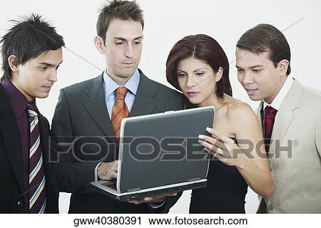 Three businessmen and a businesswoman looking at a laptop View Large Photo Image Stock Image - Three businessmen and a businesswoman looking at a laptop. Fotosearch