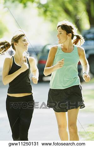Two women jogging on the road View Large Photo Image Stock Image - Two women jogging on the road. Fotosearch