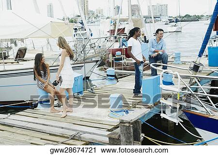 Two young couples standing on a pier View Large Photo Image Stock Image - Two young couples standing on a pier. Fotosearch