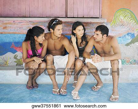 Two young men with a teenage girl and a young woman sitting together View Large Photo Image Stock Image - Two young men with a teenage girl and a young woman sitting together. Fotosearch