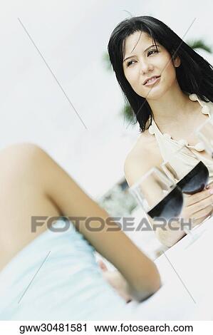 Two young women sitting at the table with glasses of wine in front of them View Large Photo Image Stock Image - Two young women sitting at the table with glasses of wine in front of them. Fotosearch