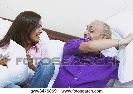 Young couple having a pillow fight View Large Photo Image Stock Image - Young couple having a pillow fight. Fotosearch