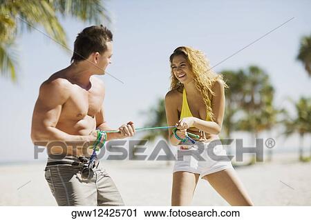Young couple standing on the beach and pulling a rope View Large Photo Image Stock Image - Young couple standing on the beach and pulling a rope. Fotosearch