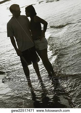 Young couple standing on the beach View Large Photo Image Stock Image - Young couple standing on the beach. Fotosearch