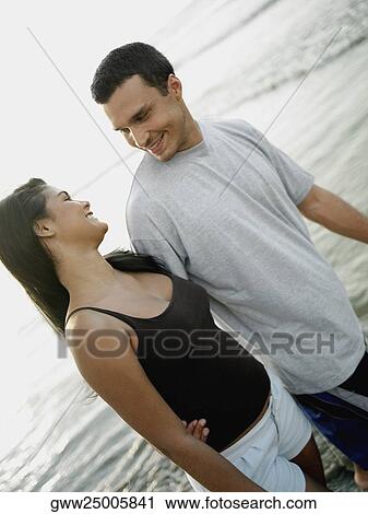 Young couple walking on the beach View Large Photo Image Stock Image - Young couple walking on the beach. Fotosearch
