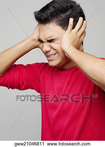 Young man covering his ears View Large Photo Image Stock Image - Young man covering his ears. Fotosearch