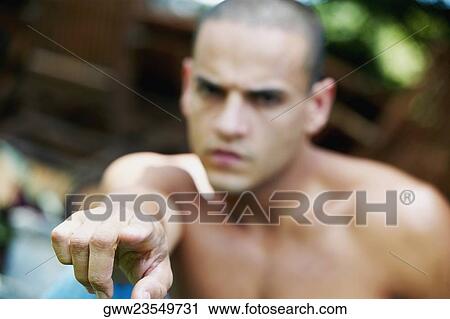 Stock Image - Young man pointing his finger in anger. Fotosearch