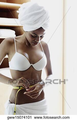 Young woman measuring her waist View Large Photo Image Stock Image - Young woman measuring her waist. Fotosearch
