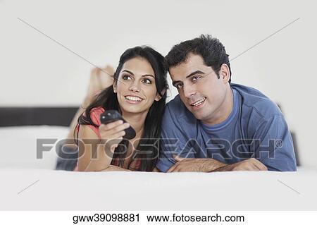 Young woman operating a remote control with a mid adult man beside her View Large Photo Image Stock Image - Young woman operating a remote control with a mid adult man beside her. Fotosearch