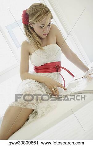 Young woman sitting on the bed and reading a book View Large Photo Image Stock Image - Young woman sitting on the bed and reading a book. Fotosearch