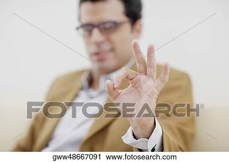 Stock Image - Businessman making an OK sign. Fotosearch