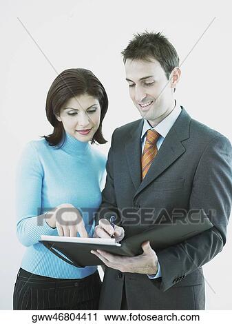 Businesswoman and a businessman looking at a personal organizer View Large Photo Image Stock Image - Businesswoman and a businessman looking at a personal organizer. Fotosearch