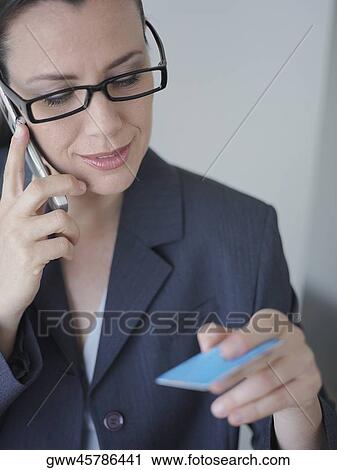 Businesswoman talking on a mobile phone and holding a credit card View Large Photo Image Stock Image - Businesswoman talking on a mobile phone and holding a credit card. Fotosearch