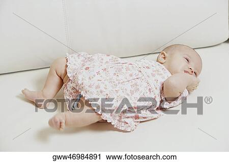 Close-up of a baby girl lying on the bed View Large Photo Image Stock Image - Close-up of a baby girl lying on the bed. Fotosearch