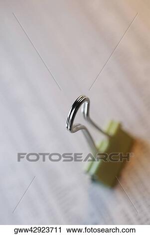 Stock Image - Close-up of a binder clip on a document. Fotosearch