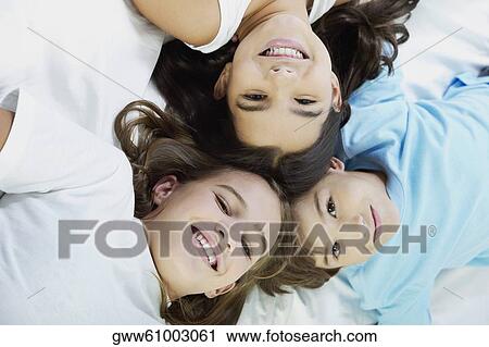 Close-up of a boy and his two sisters lying on the bed View Large Photo Image Stock Image - Close-up of a boy and his two sisters lying on the bed. Fotosearch